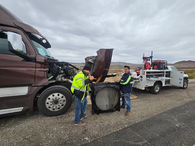 Chuy's Towing & Tire Service technicians repairing a semi-truck radiator on the I-15